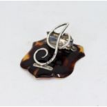 A silver musical note paper clip mounted on a tortoise shell shield, hallmarked Birmingham 1900-1,