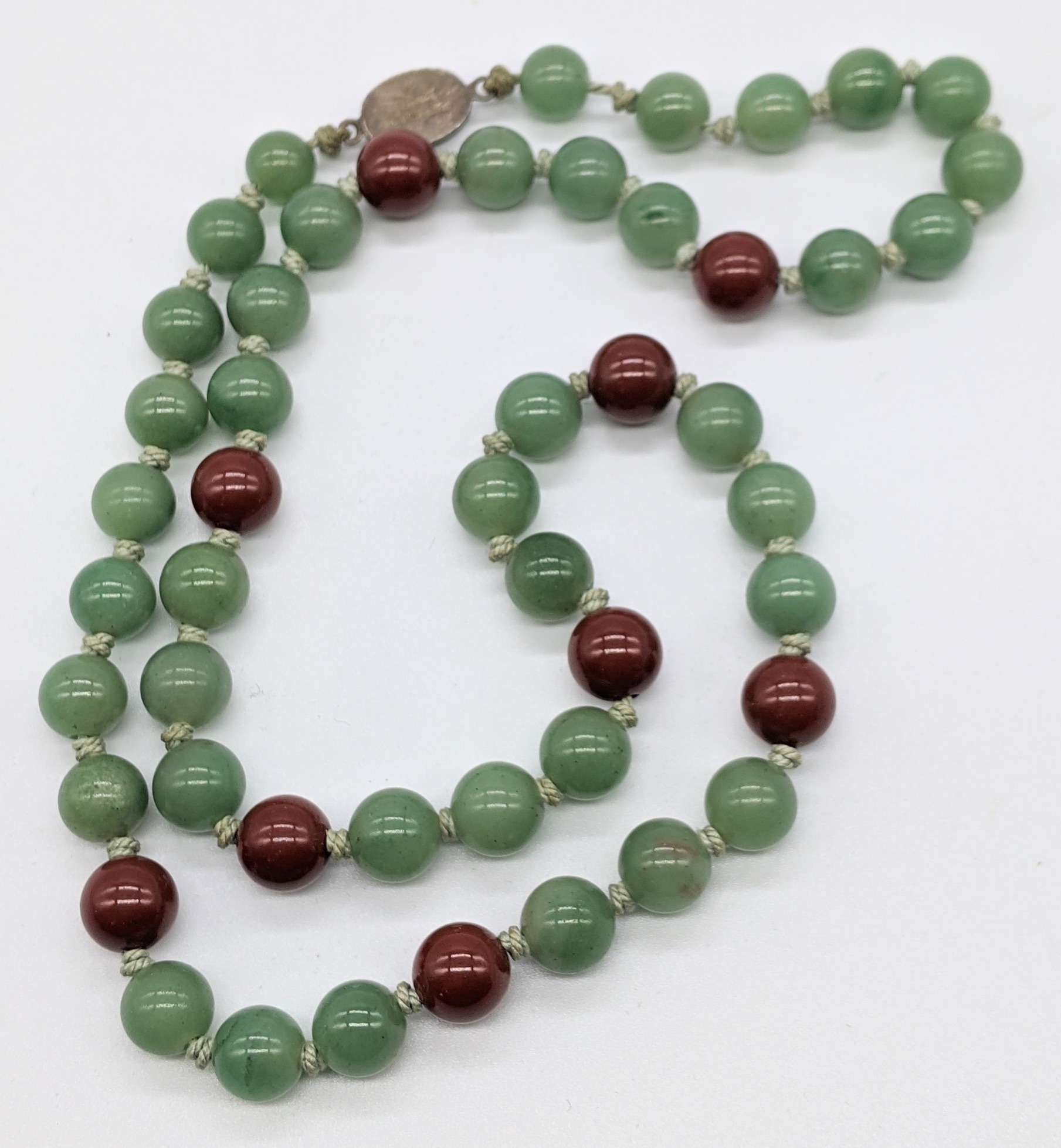 A Jade bead necklace, silver clasp