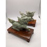 A pair of jadeite dragons, raised on wooden bases, H.12cm L.14.5cm