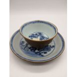 An 18th century Chinese Nanking blue and white tea cup and saucer with Batavian brown coating, H.5.