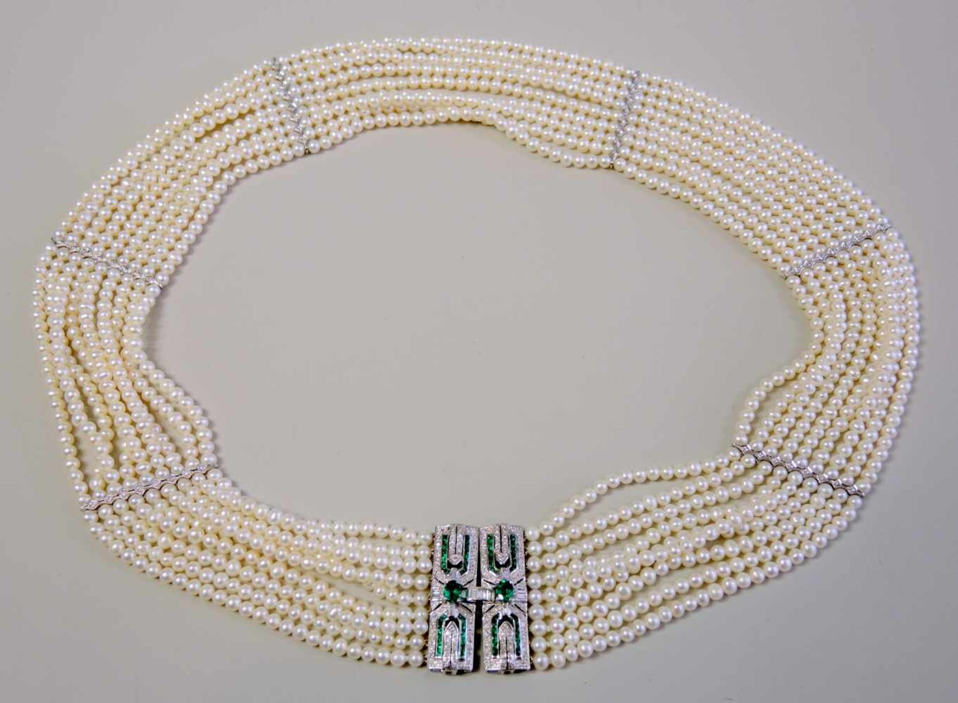 Feines Collier im Stil des Art-décos18 K. Weißgold. Neunreihige Perlenkette mit sechs Stegen und