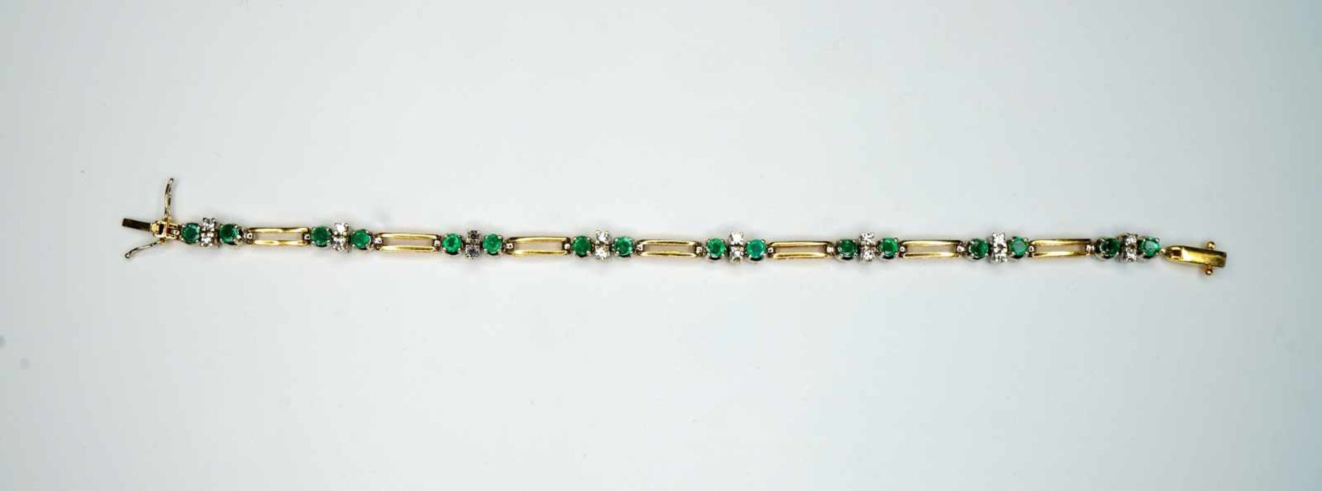Damenarmband18 K Weiß- und Gelbgold. Feingegliedertes Armband. Smaragde und Diamanten