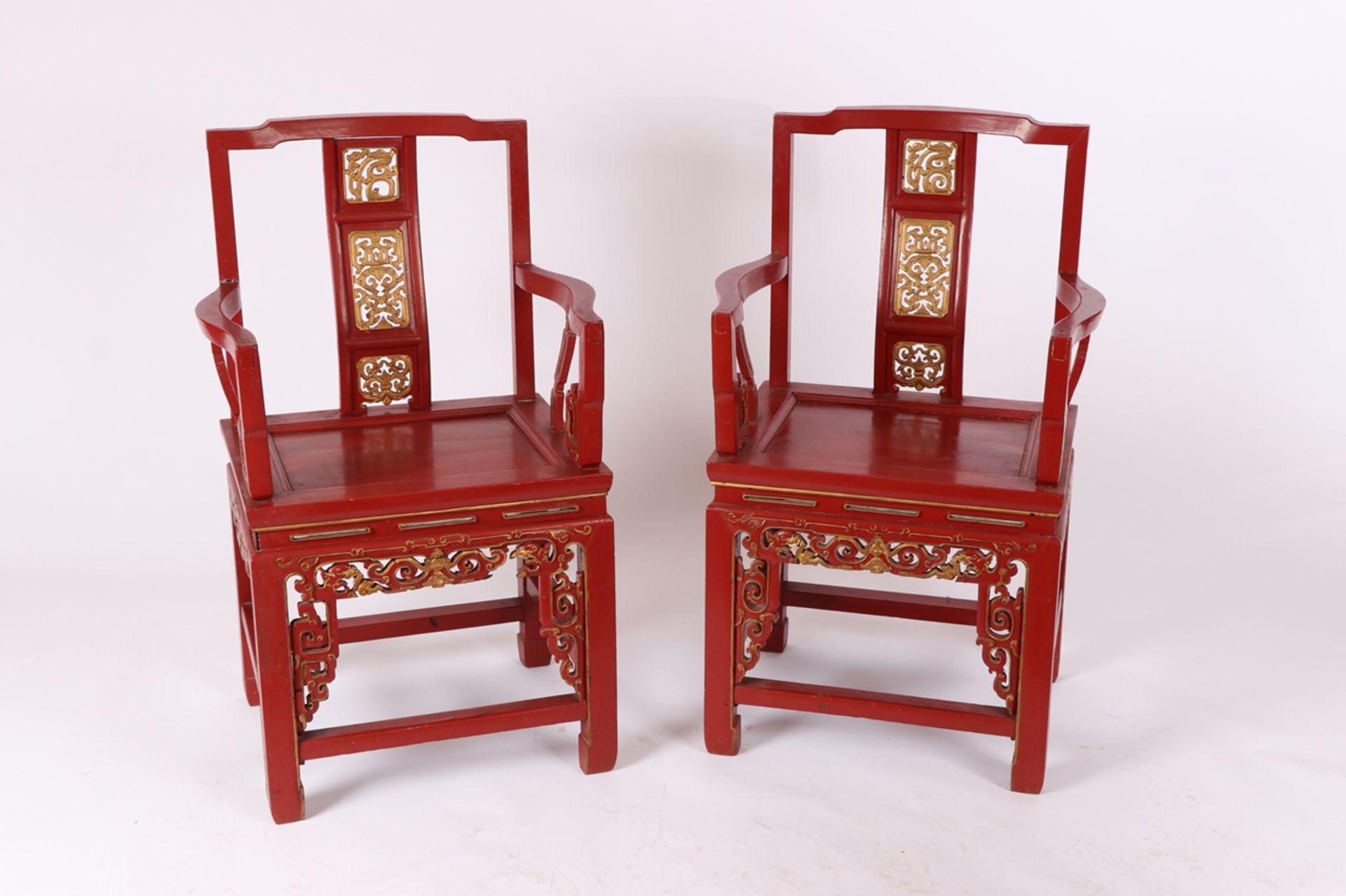 Paar Rotlack-Armlehnstühle, China um 1900Hartholz. Geschnitzte Elemente vergoldet. Armlehnen