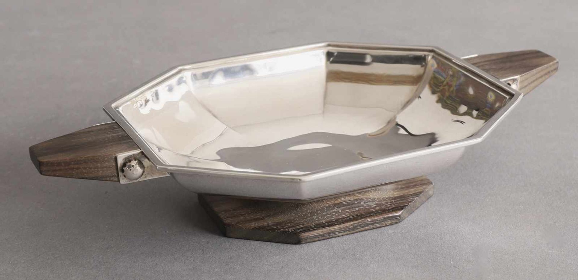 Bowl, Silver, woodBowl. Silver, wood. Faceted wall. Wooden handles and stand. 4.7 x 12.3 x 22 cm.