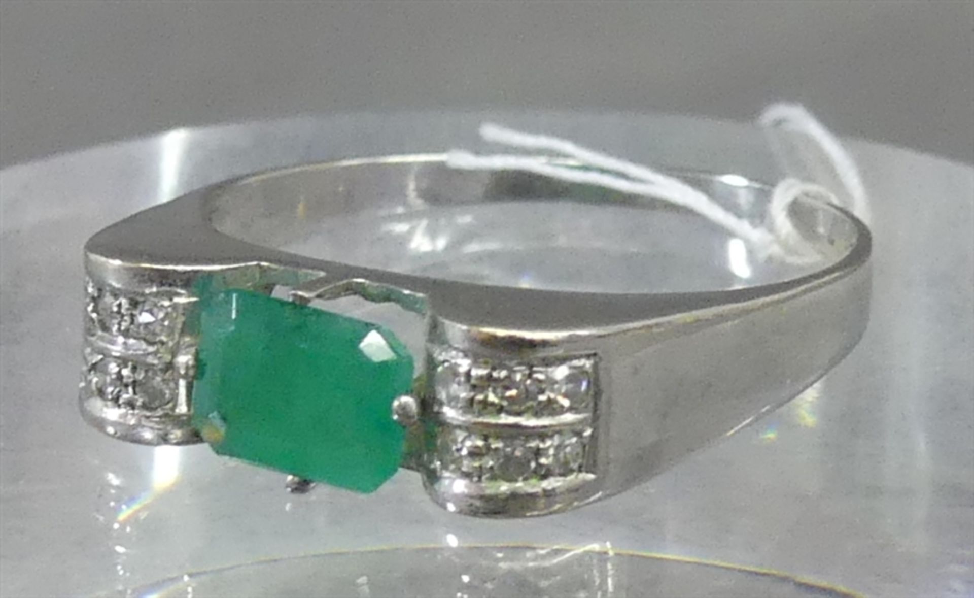 Damenring 14 kt. Weißgold, 1 Smaragd, Emeraldcut, 12 kl. Diamanten als Besatz, ca. 4 g schwer, RM