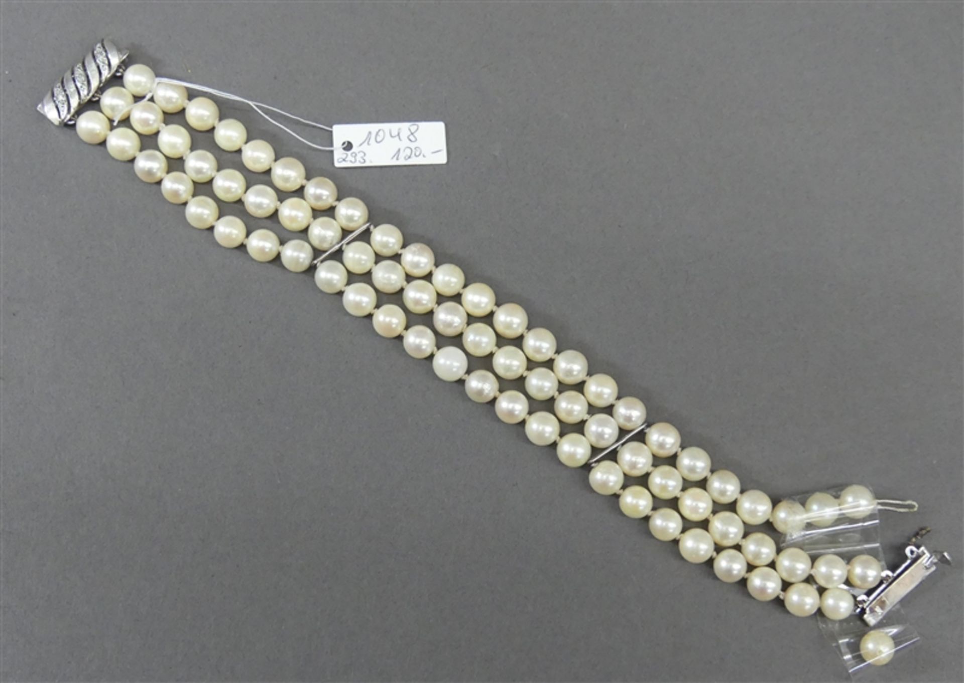 Armband 14 kt. Weißgold-Verschluss, ca. 75 Zuchtperlen, weiß, 1 Strang beschädigt, 3-reihig, l 19
