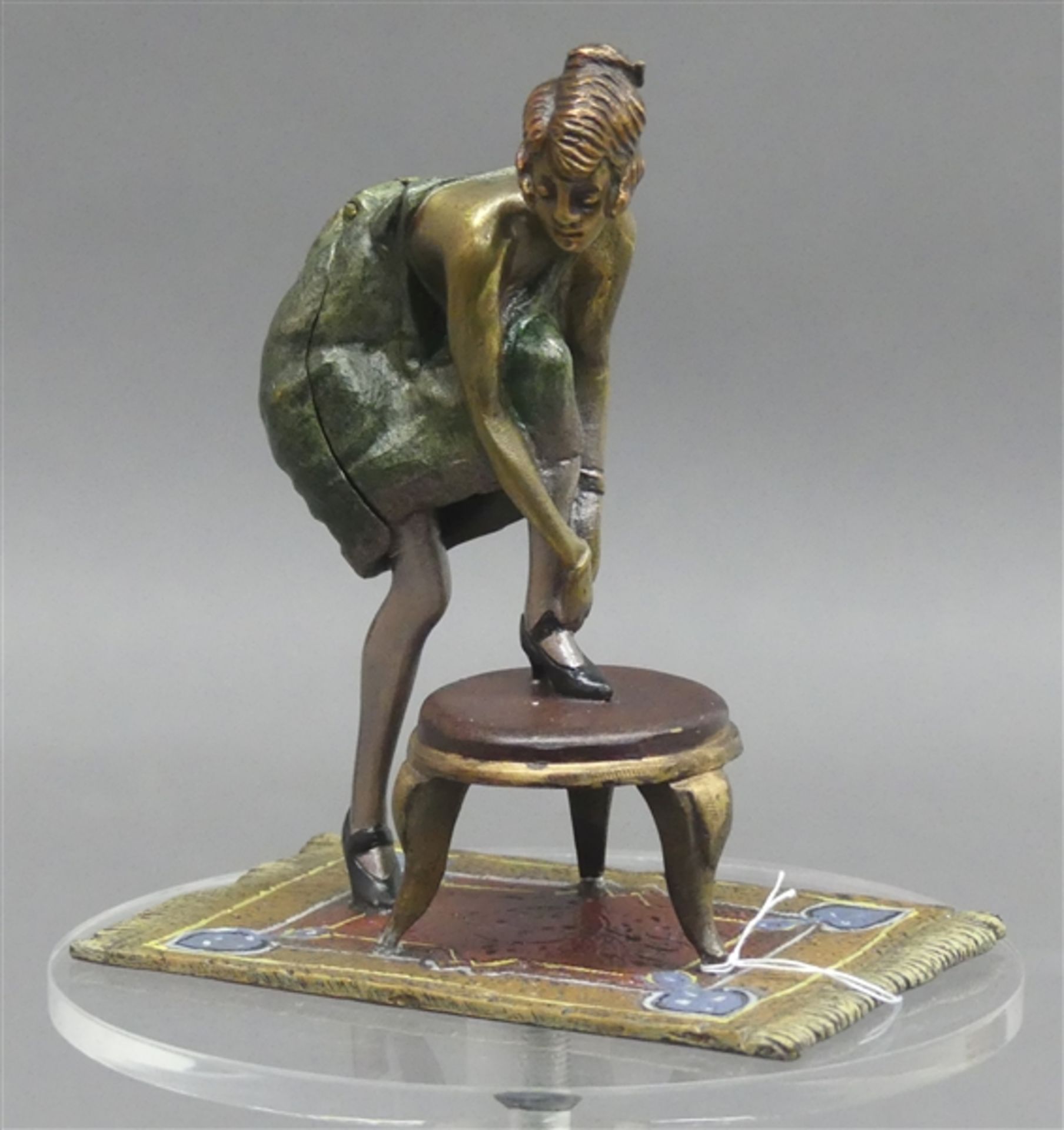 Wiener Bronze erotisch, bunt bemalt, Frau stützt Fuß ab auf einem Beistelltisch auf einem Teppich,