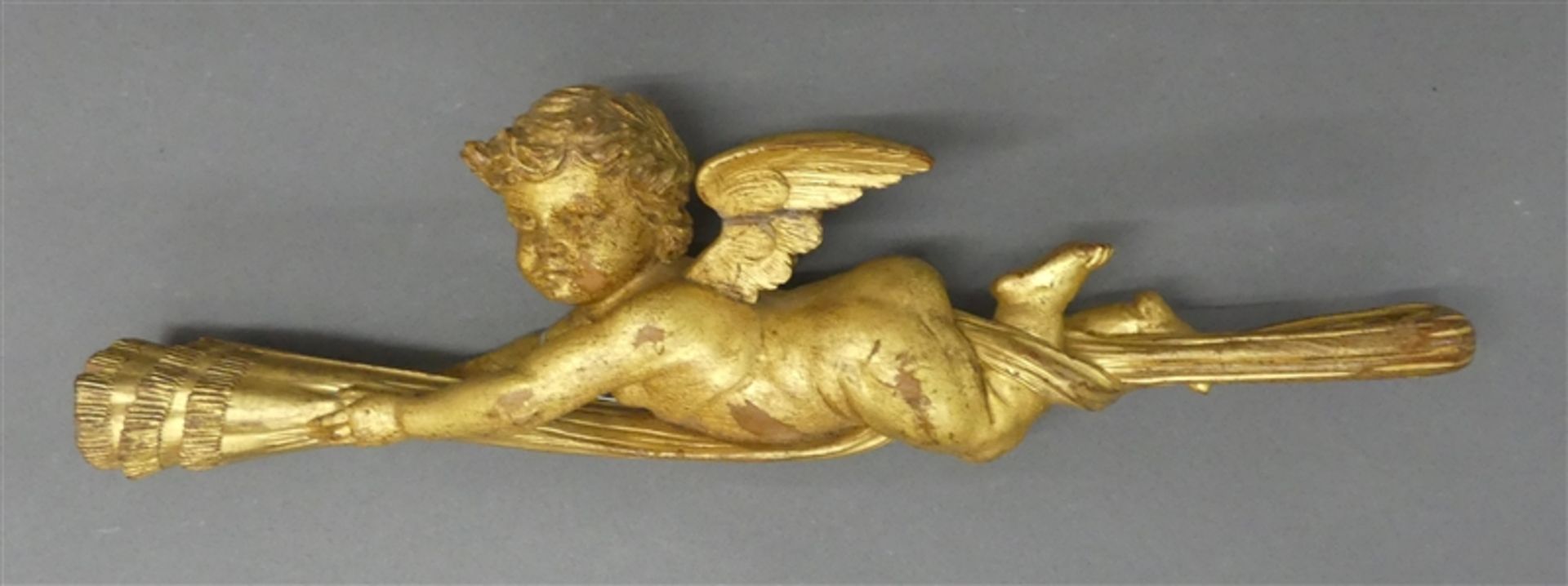 Holzskulptur liegender geflügelter Putto am Vorhang ?, Goldfassung, leichte Fassungsschäden, b 34