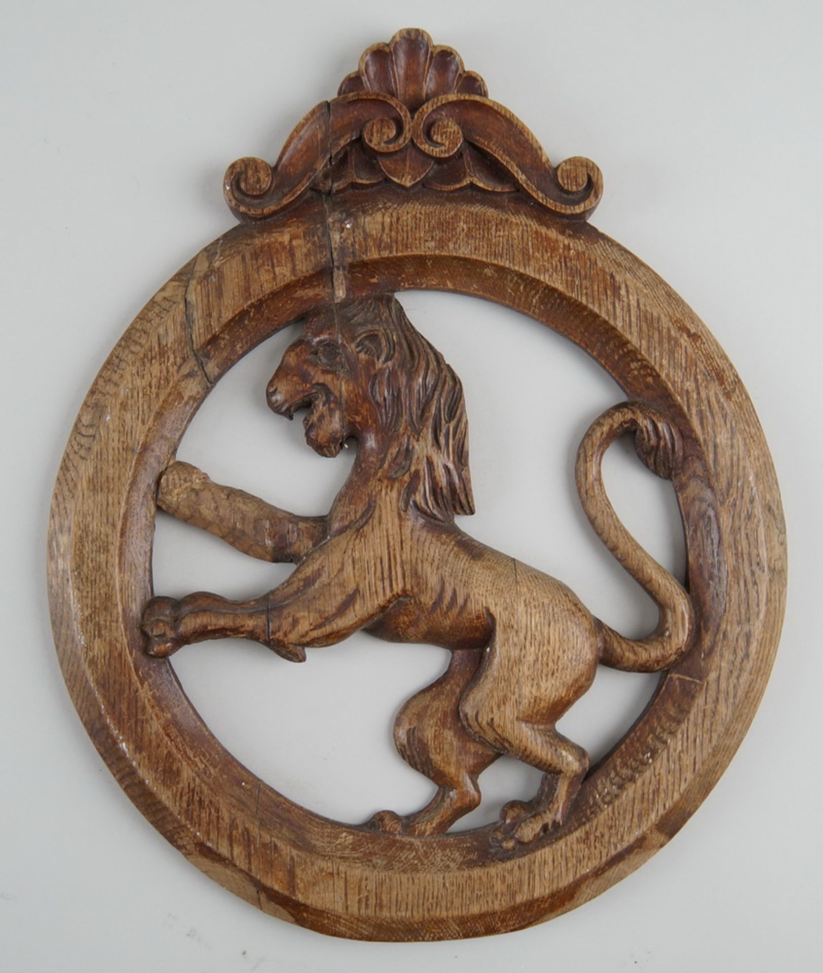 Rundes Relief mit Bekrönung, im Zentrum ein Löwe, Holz geschnitzt, Altersspuren, 39x31cm
