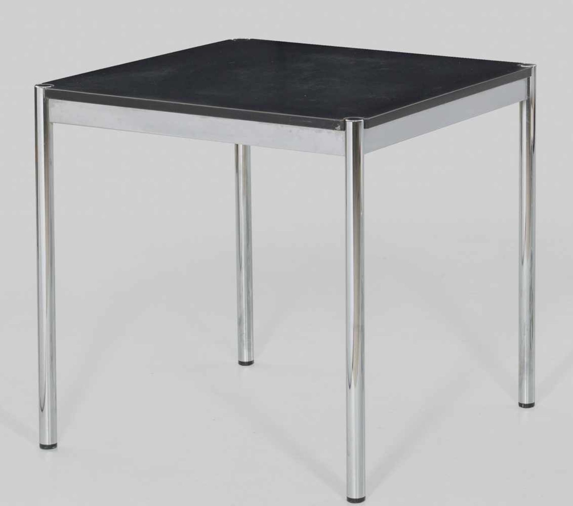 Tisch von USM HallerVerchromtes Metall sowie schwarz beschichtetes Holz. Kräftige Rundstäbe als