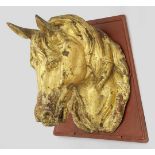 PferdekopfZinkguss, goldbronziert bzw. vergoldet. Montiert auf trapezförmiger Wandplatte aus rot