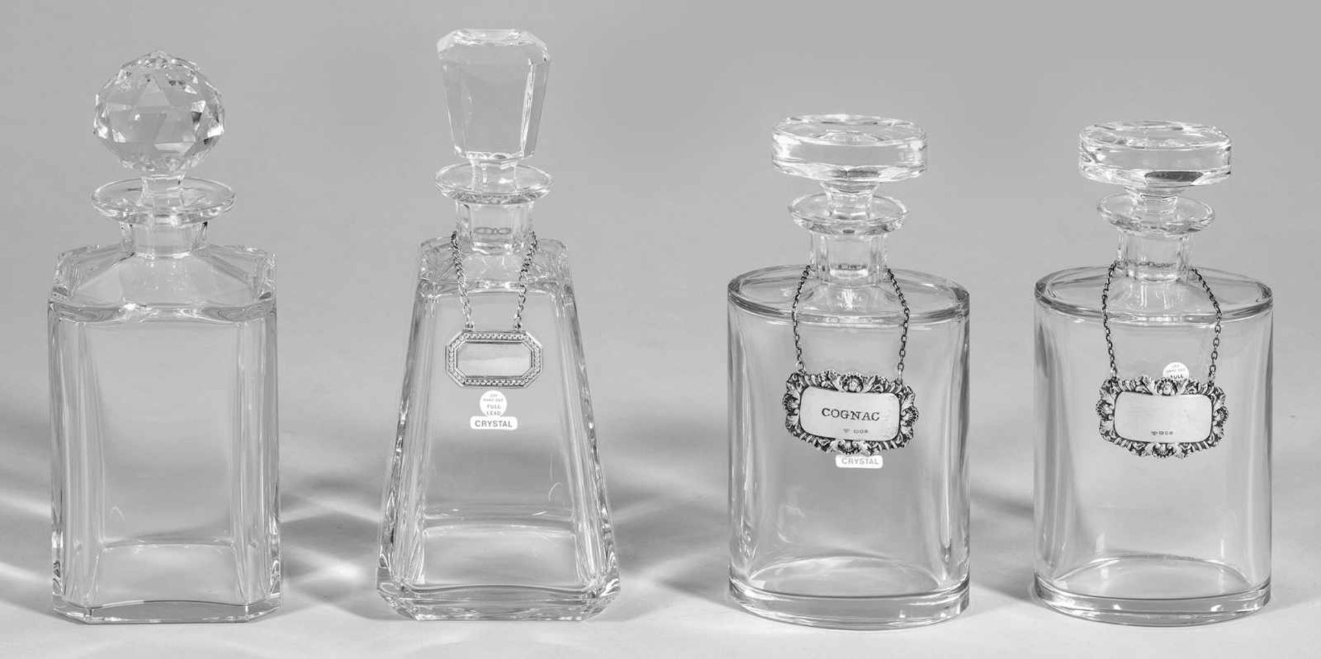Vier KaraffenKristallglas. Ovaler, quadratischer bzw. konischer Korpus mit abgesetzter Schulter.