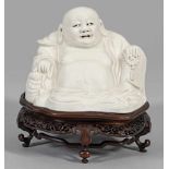 Blanc-de-chine Figur "Sitzender Budai"Dehua-Porzellan. Als dickbäuchiger, lachender Mönch mit