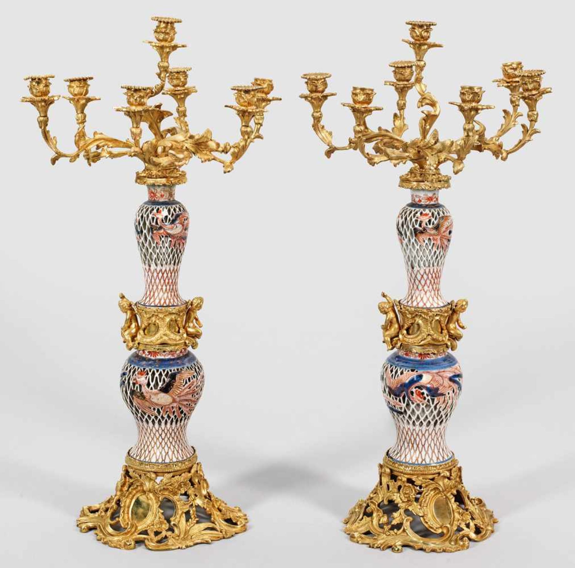 Paar große Prunkgirandolen mit Imari-Porzellan7-flg.; Bronze, vergoldet sowie durchbrochen