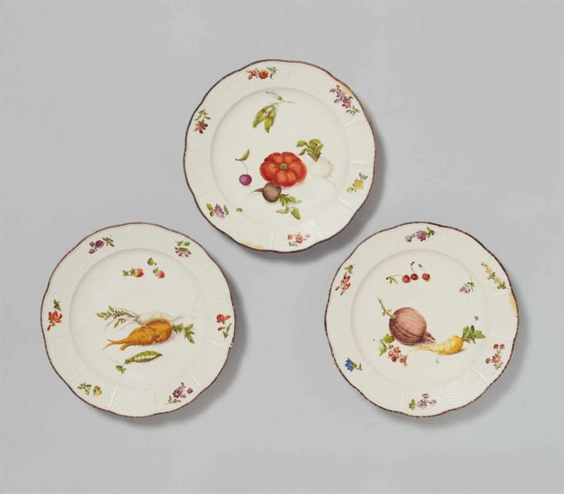 Three Vienna porcelain plates with fruit and vegetable decorWith ozier mouldings and scattered