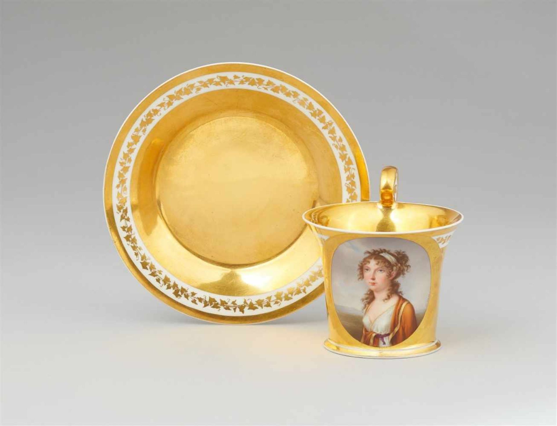 A Vienna porcelain cup and saucer with a portrait of a young ladyBell-shaped cup with tall scroll