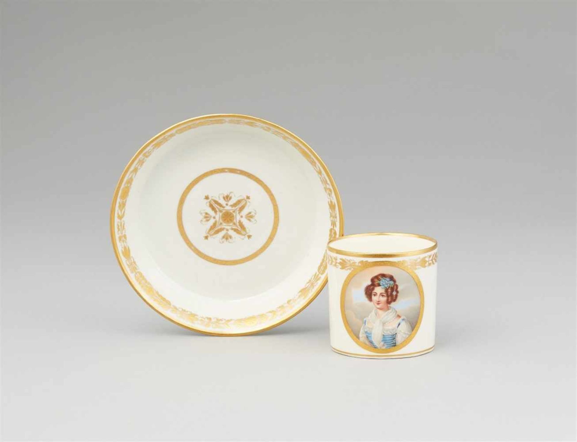 A Vienna porcelain cup with a portrait of a young ladyOf cylindrical form with original saucer. Blue