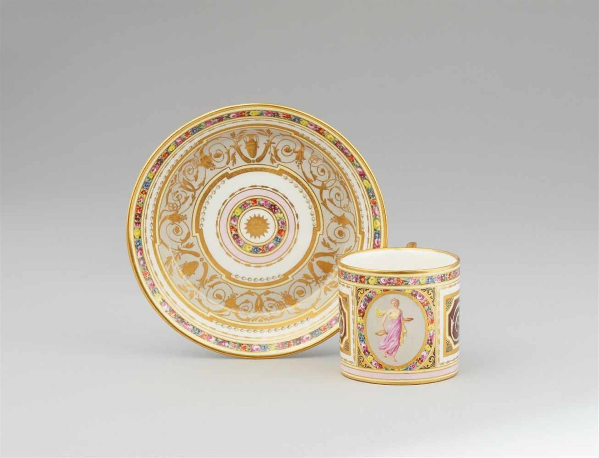 A Vienna porcelain cup and saucer with floral wreathsCylindrical cup decorated with a figure of a