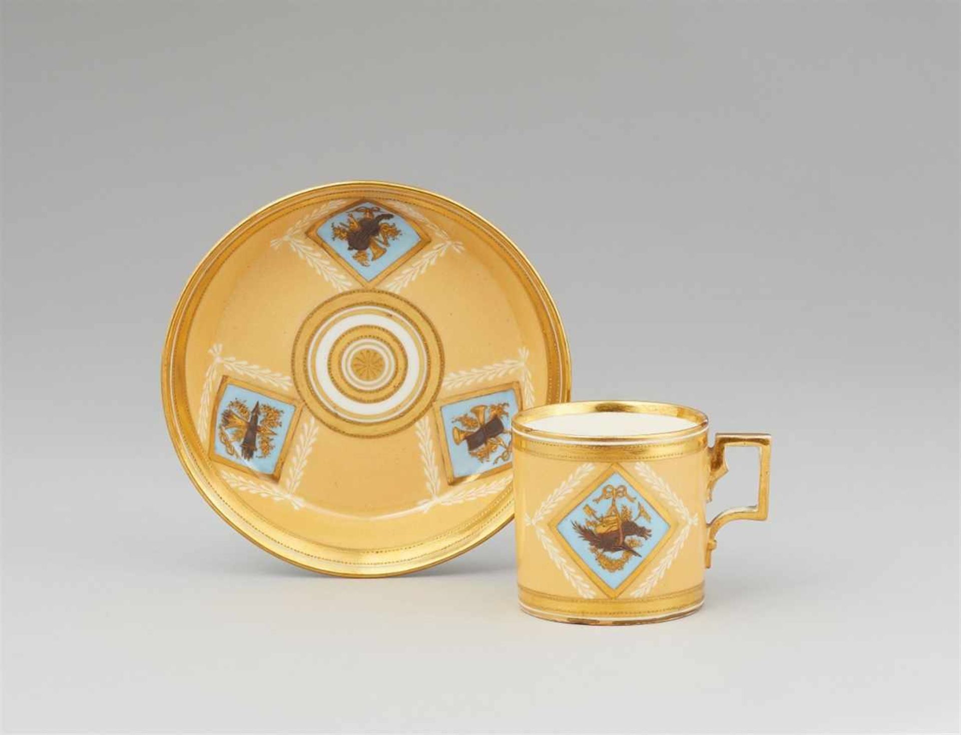 A Vienna porcelain cup and saucer with trophy decorOf cylindrical form with original saucer. Blue