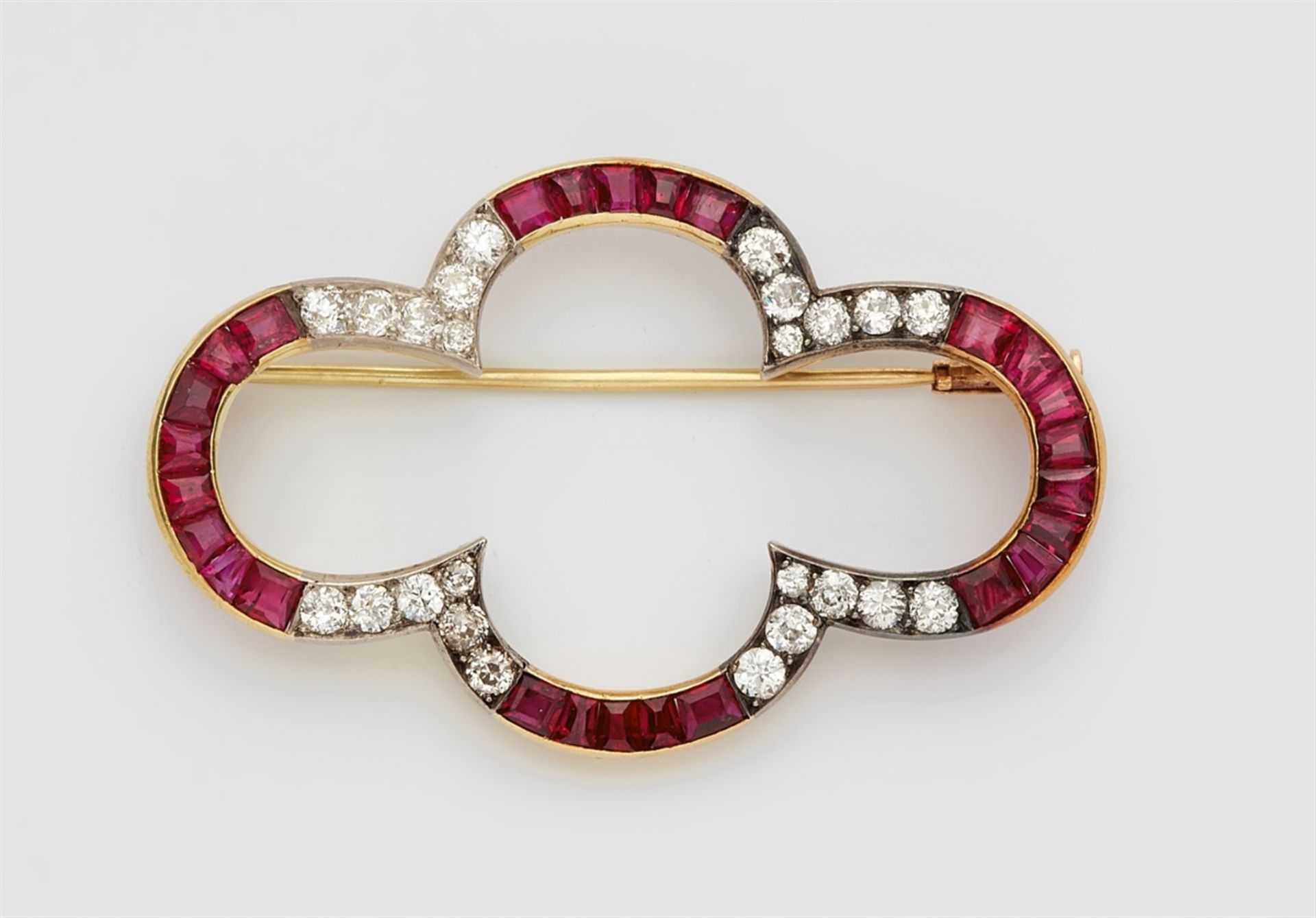 An 18k gold, diamond and ruby broochPierced quatrefoil form set with 26 calibrated natural rubies (