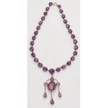 A 14k red gold and amethyst necklace with pendantA slightly graduated rivière necklace set with 29