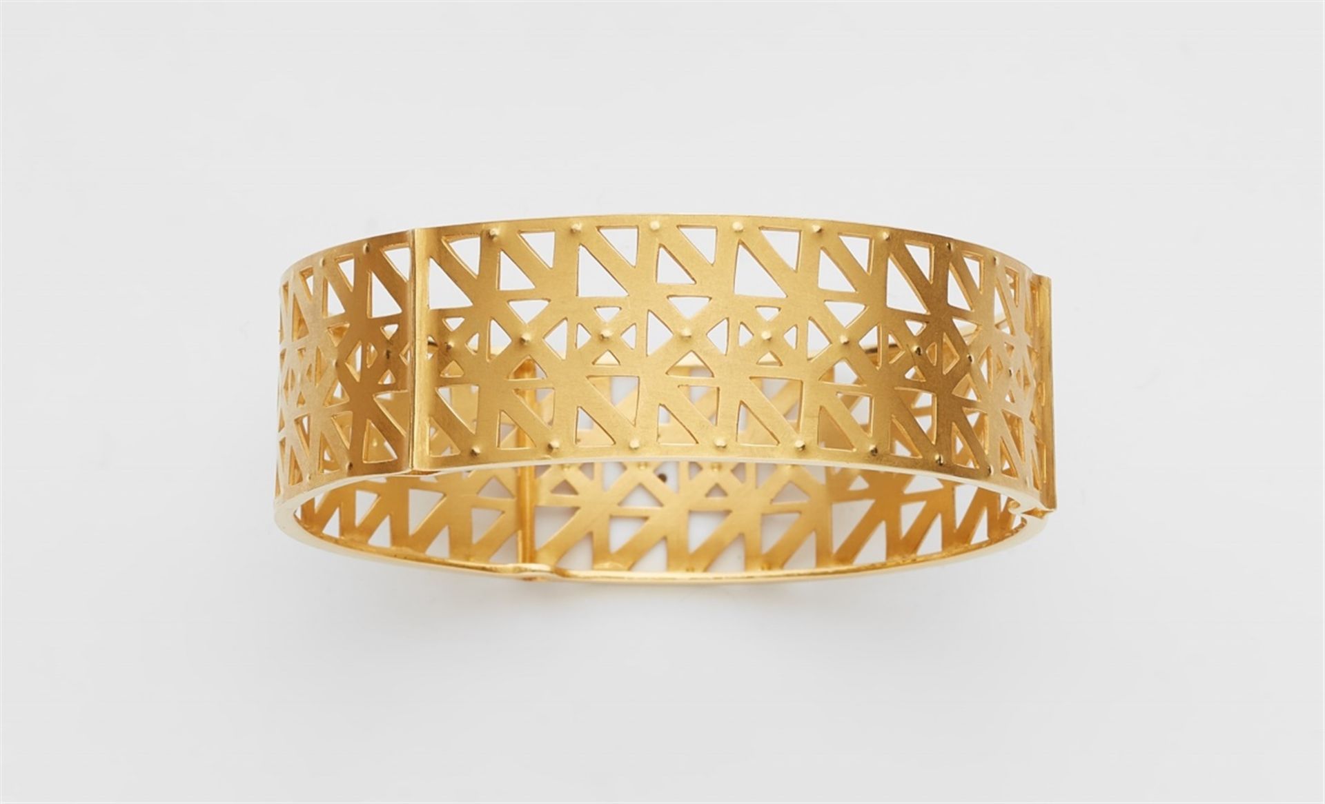 An 18k gold bangleDesigned as a gold band with fine pierced geometric decor and embossing. W 2 cm.