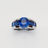 A platinum and sapphire ringThe band set with six carré-cut sapphires (in total c. 4 ct, very fine