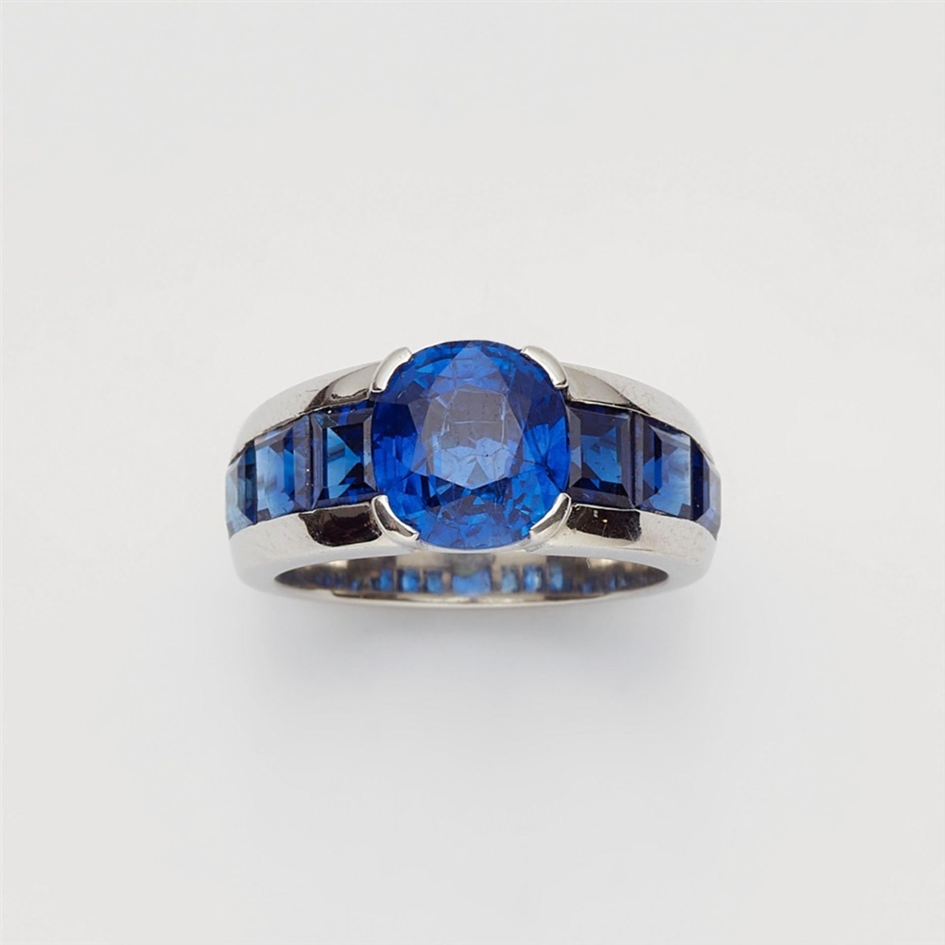 A platinum and sapphire ringThe band set with six carré-cut sapphires (in total c. 4 ct, very fine