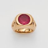 An 18k gold and pink tourmaline mask ringA solid gold signet ring, the shoulders each decorated with