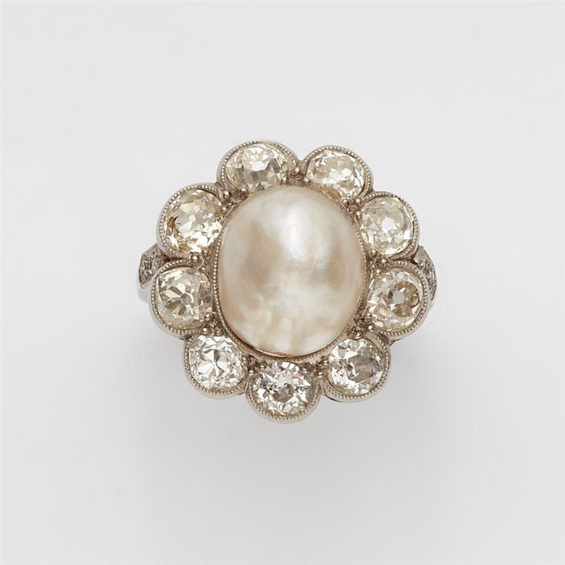 A Belle Epoque diamond and pearl ringA platinum ring with diamond set shoulders and a flower-