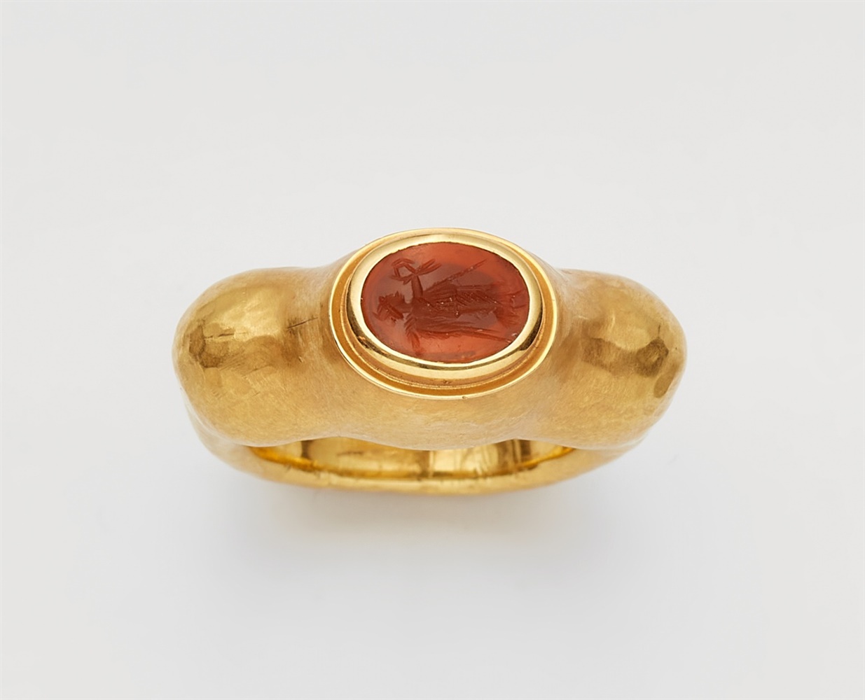An 18k gold ring with an ancient Roman carnelian intaglioForged matte gold band with raised