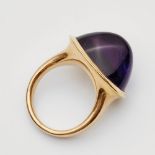 An 18k gold and amethyst ringThe oval bezel set with a sugarloaf-cut amethyst (c. 20.50 x 13.99