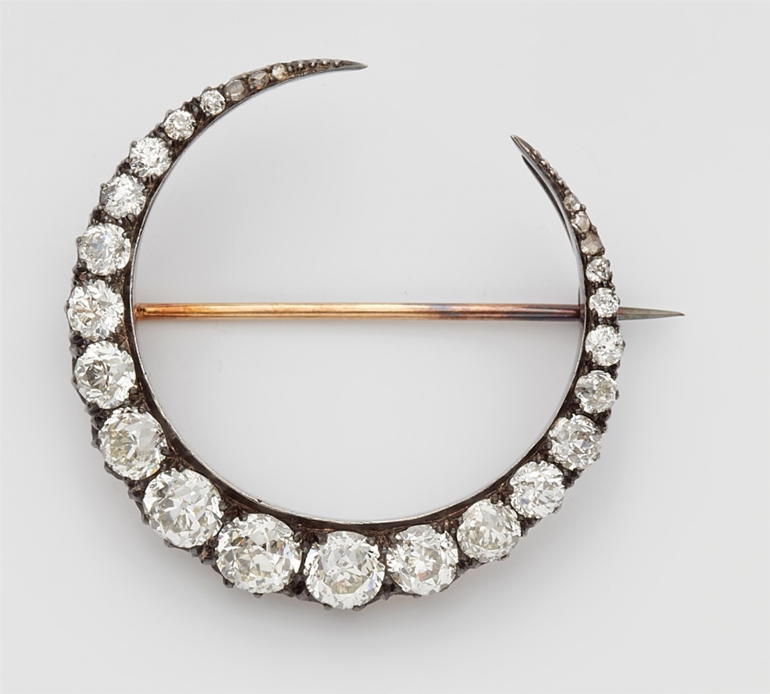 A diamond half moon broochA 14k gold and silver brooch set with six tiny rose-cut diamonds and 19