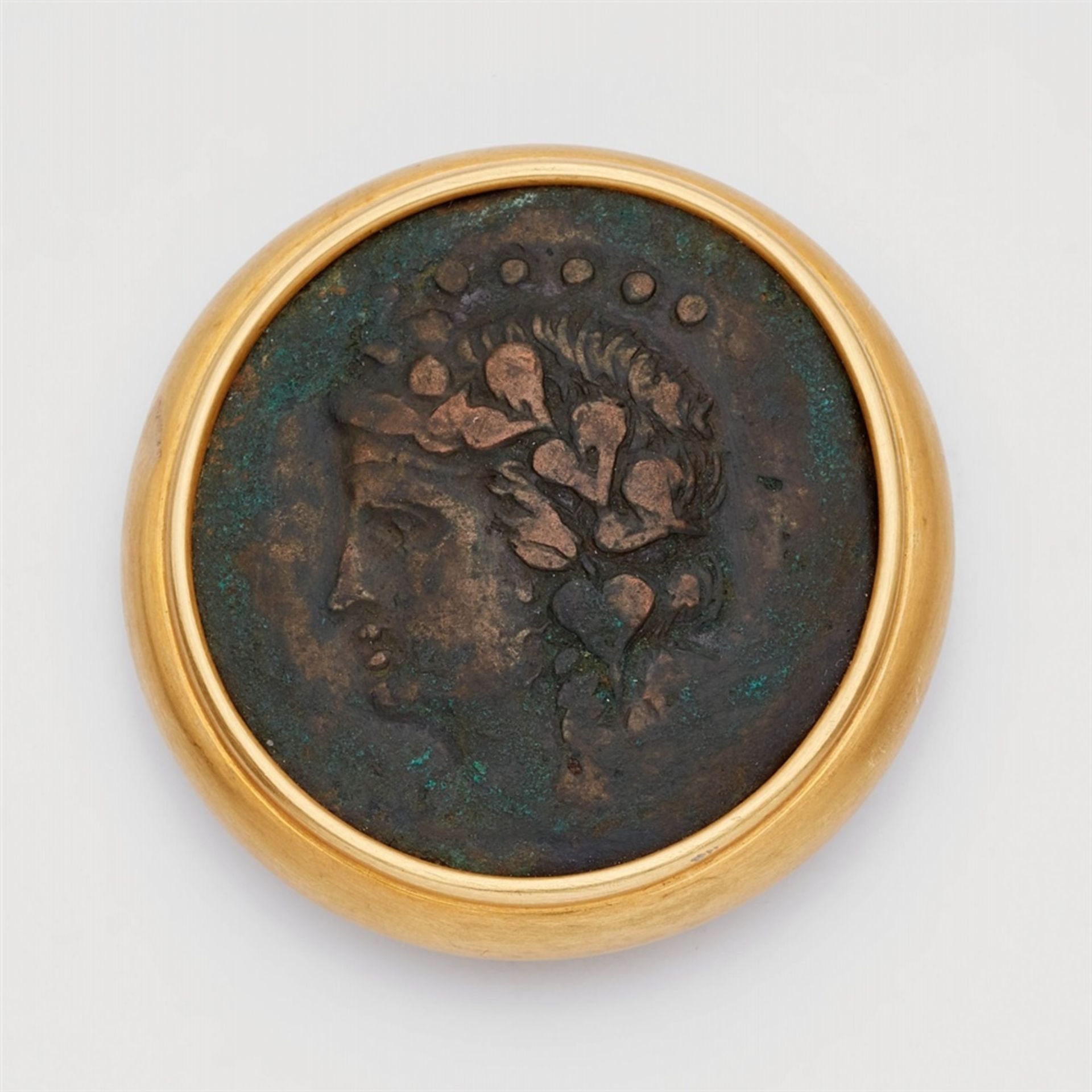 An 18k gold brooch with a Hellenistic bronze coinAn ancient bronze drachmae with the head of