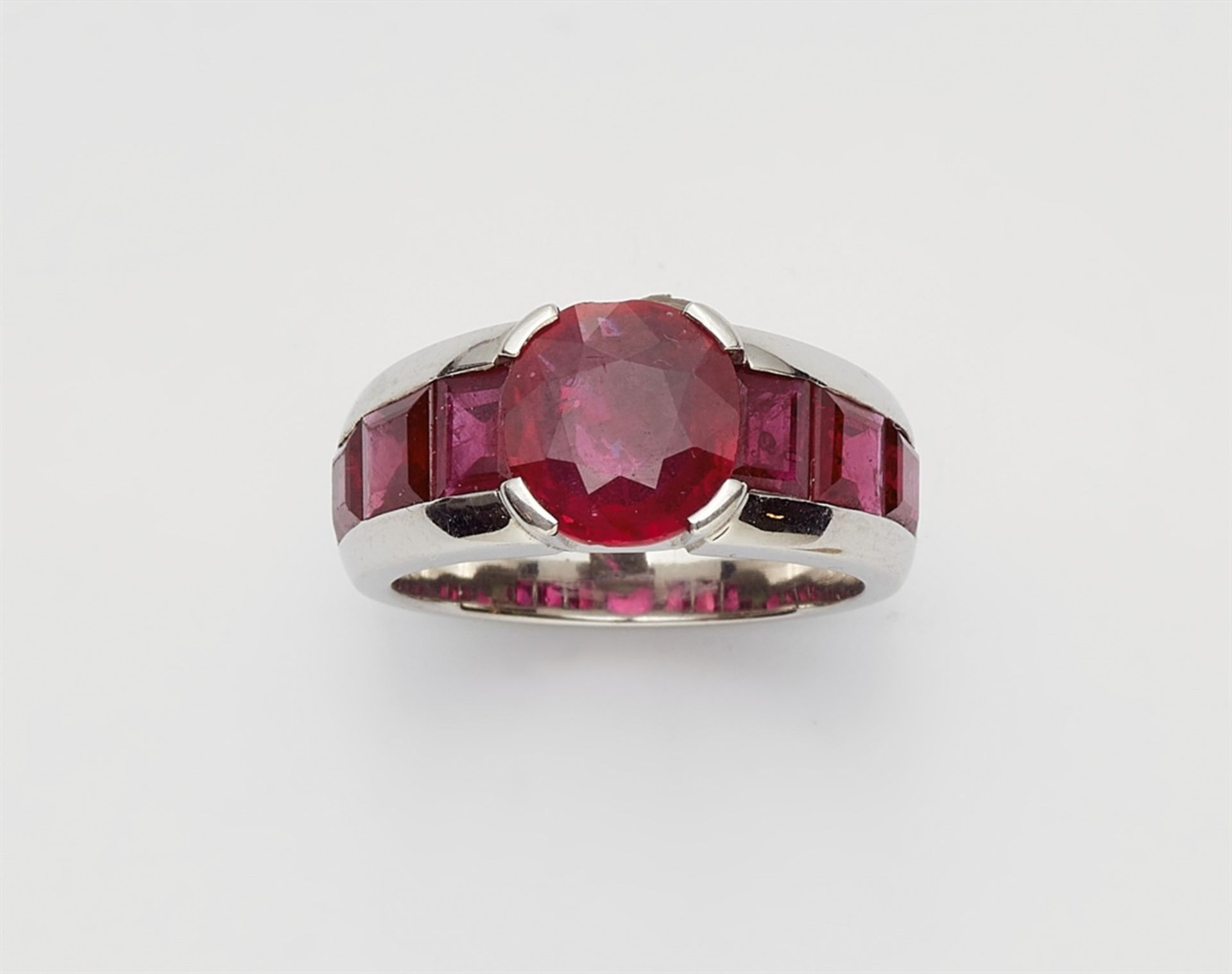 A platinum and ruby ringThe ring band set with six carré-cut rubies (in total c. 4 ct, very fine