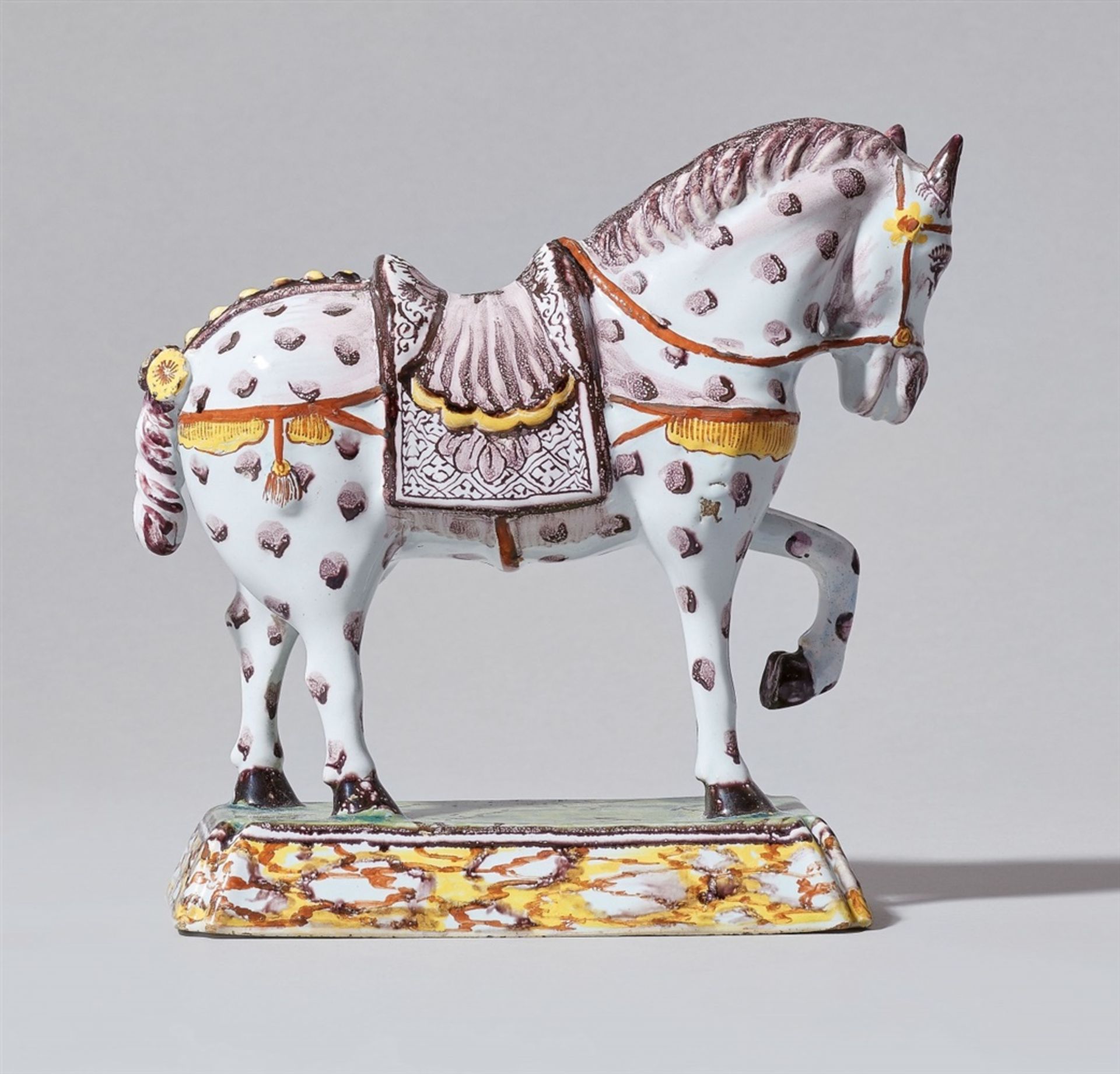 A Delftware faience model of striding horseA horse with saddle and bridle and flowers braided into