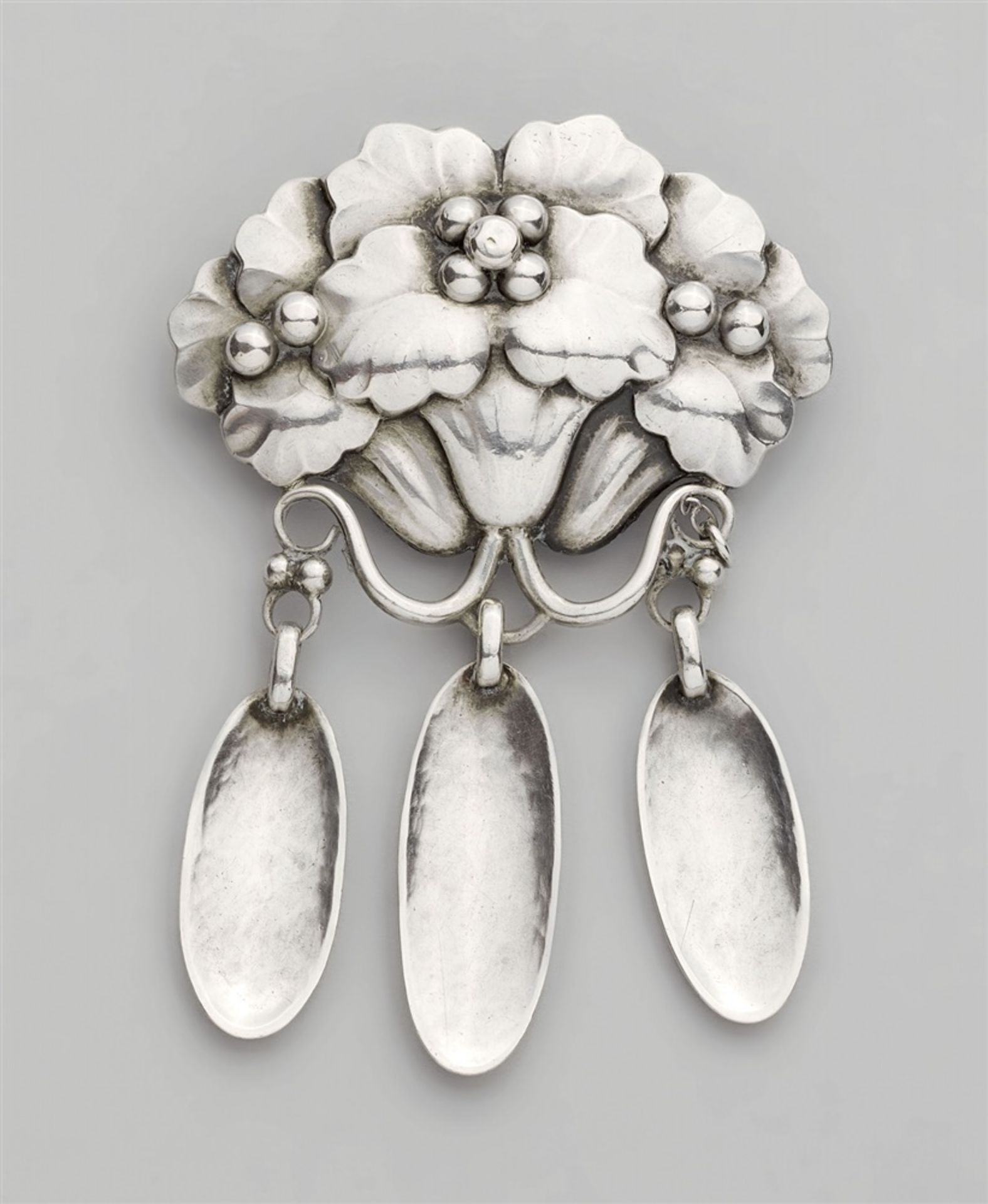 A Jugendstil silver pin by Georg Jensen, model no. 122With a design of three flowers hung with