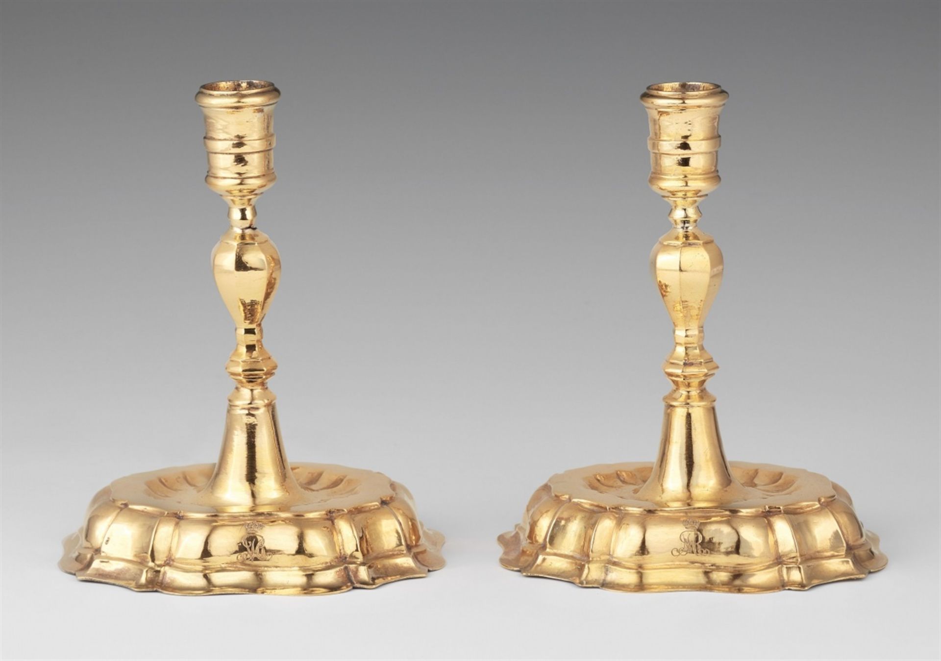 A pair of Breslau silver candlesticksSilver-gilt candlesticks with baluster-form shafts issuing from