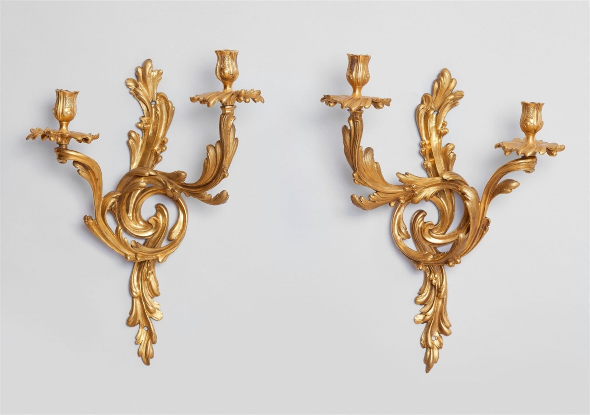 A pair of Louis XV ormolu appliquesTwo-flame fire-gilt bronze appliques cast in several pieces and