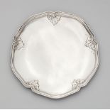 A Dresden Rococo silver platterSilver. A round, scalloped platter, the moulded rim decorated with