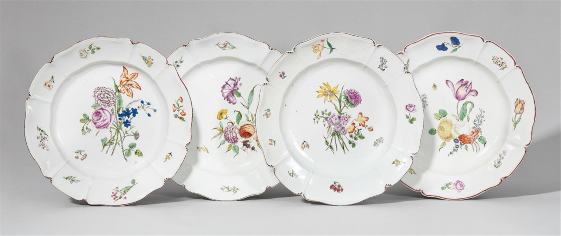 Four Nymphenburg porcelain plates with bouquetsScalloped plate with scattered flowers. Impressed