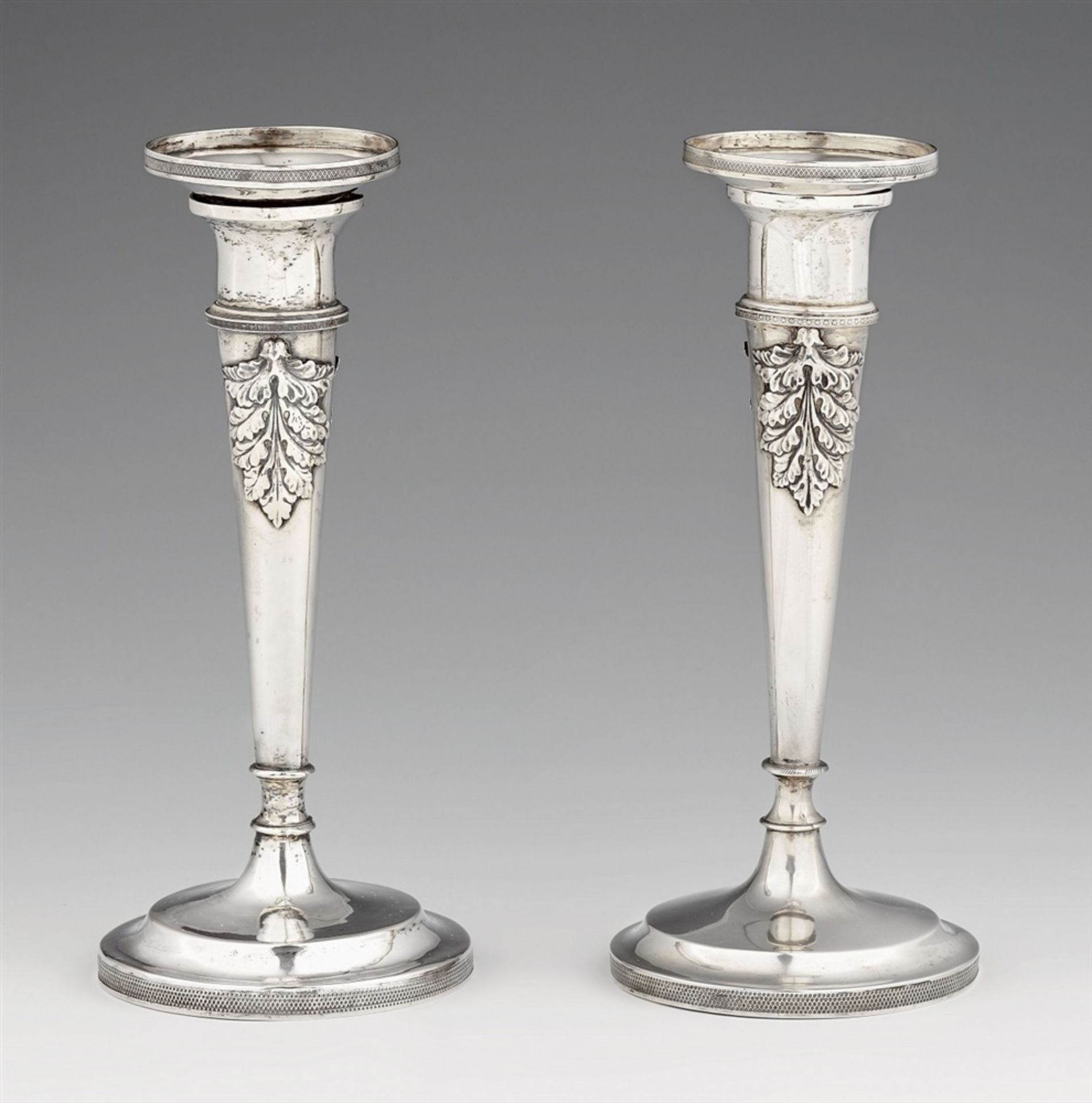 A pair of Würzburg silver candlesticksSilver. Tapering column shafts with acanthus relief