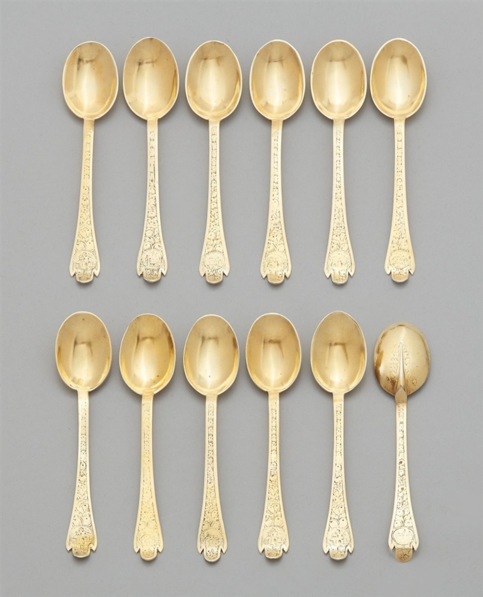 12 Baroque silver spoonsSilver-gilt spoons with oval bowls, the terminals decorated on either side