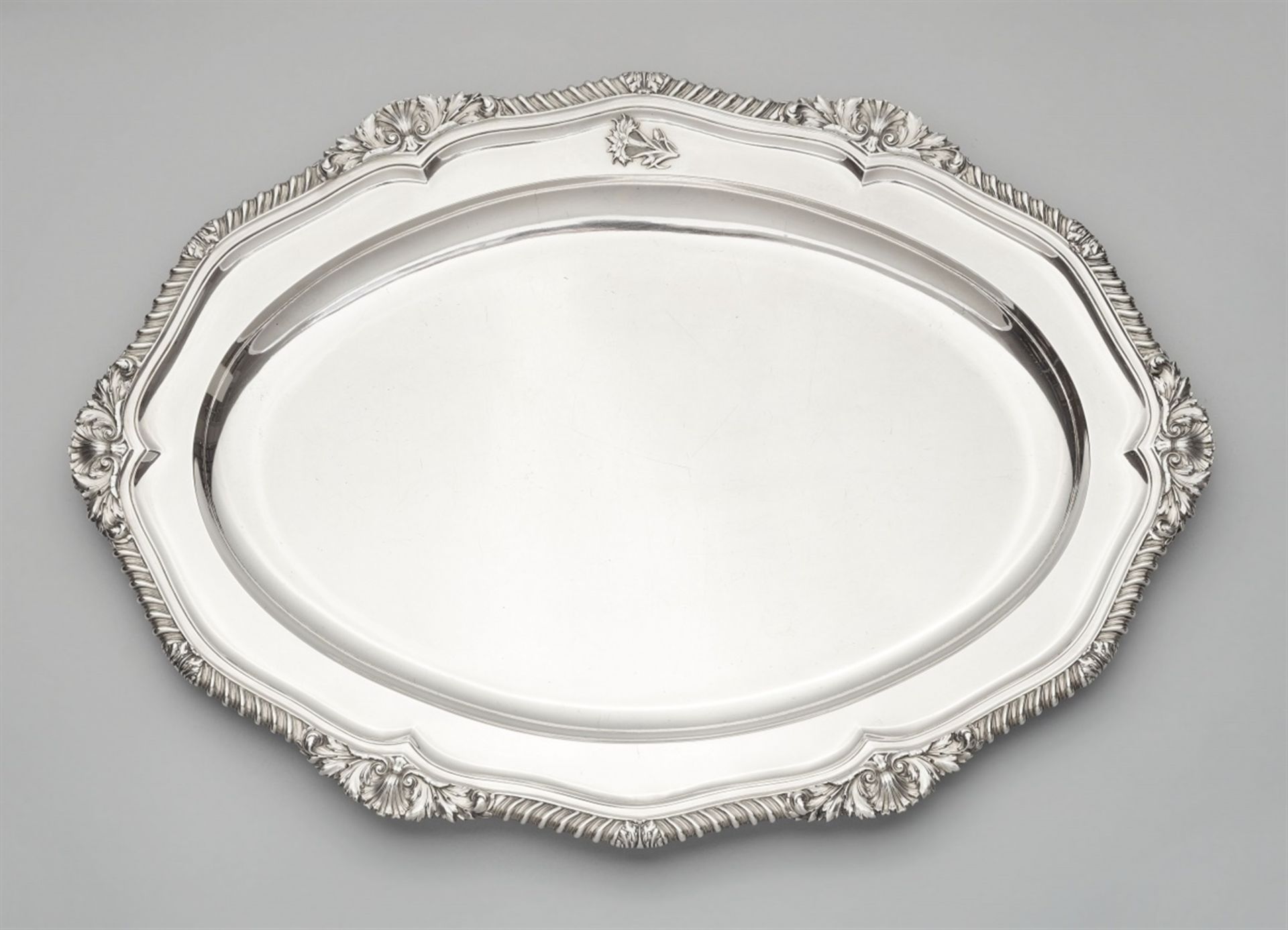 A large George III silver platterA large scalloped oval platter, the gadrooned rim with a