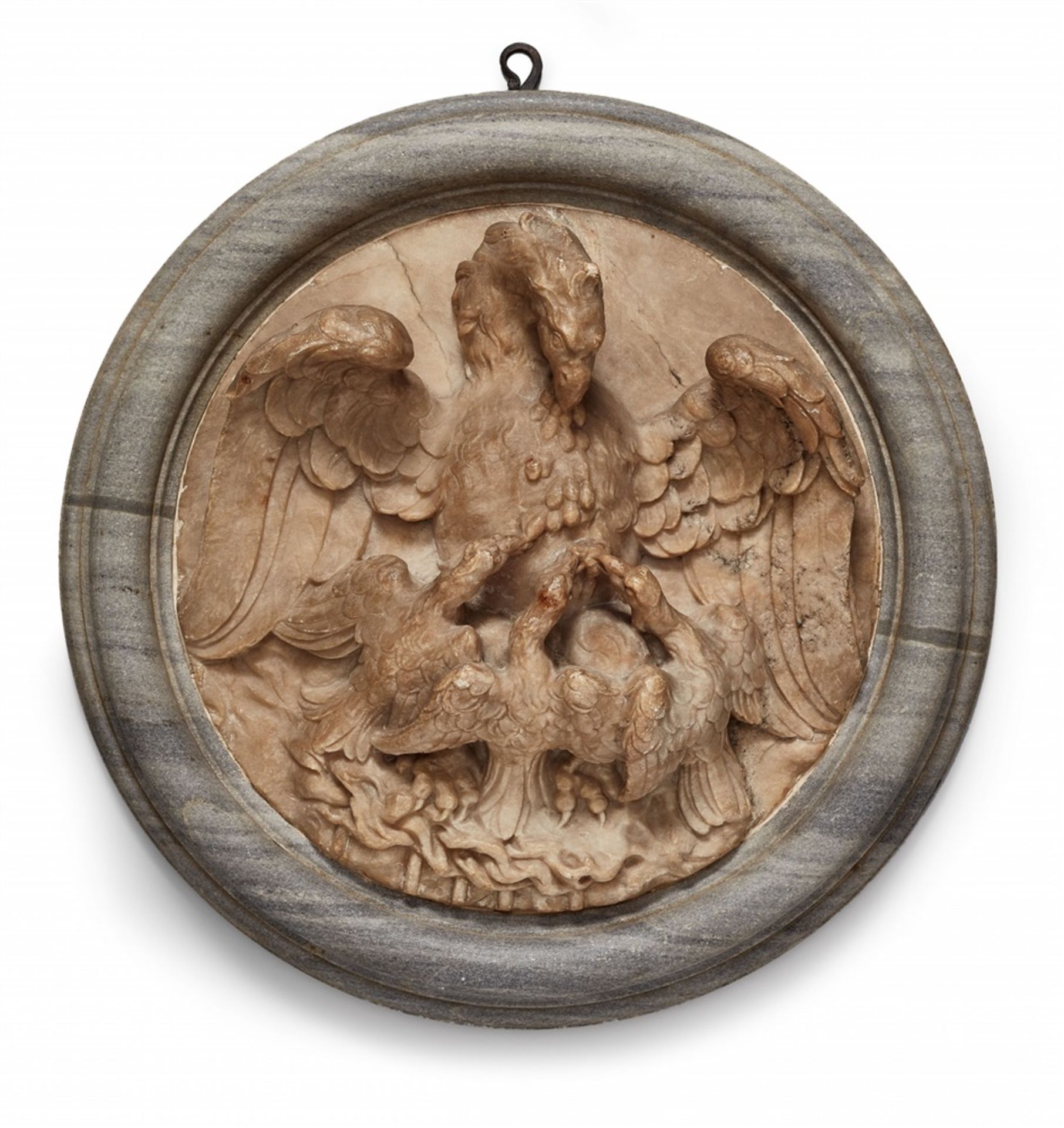 A relief plaque with an allegorical depiction of a pelicanAn alabaster and grey marble tondo with