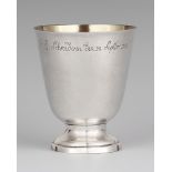 A Kassel silver beakerSilver. A cylindrical beaker on a waisted foot, the rim engraved with a