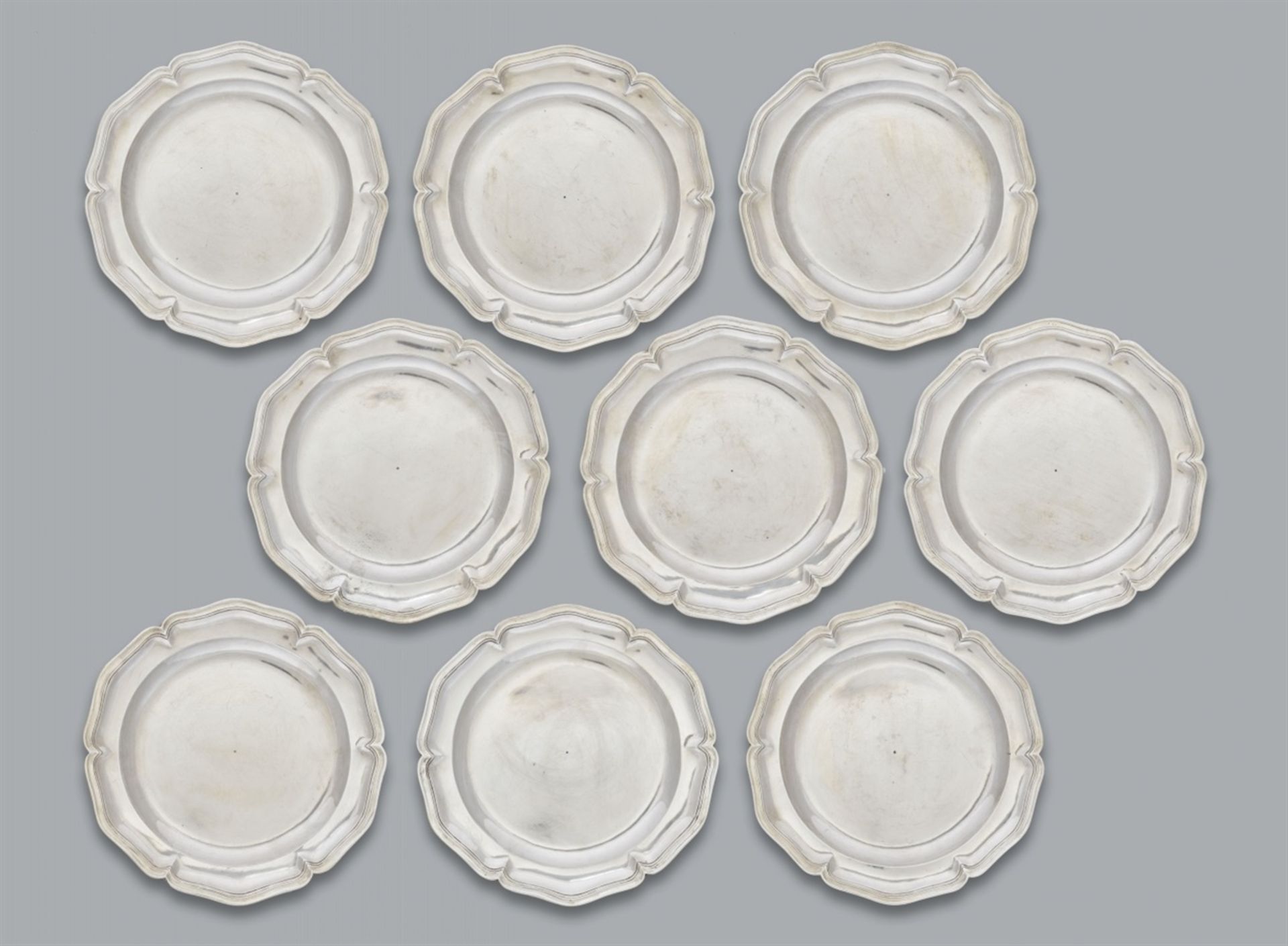 Nine Spanish silver platesRound scalloped dishes with moulded rims. Engraved with the owner's