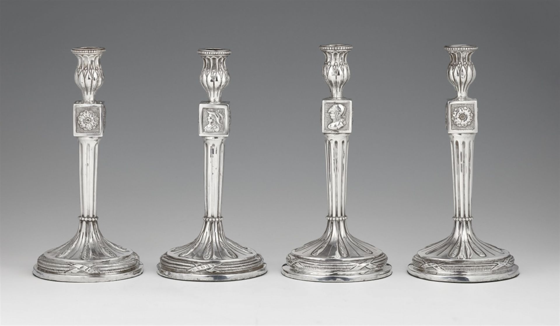 Four Antwerp silver candlesticksTwo near identical pairs of silver candlesticks with fluted column