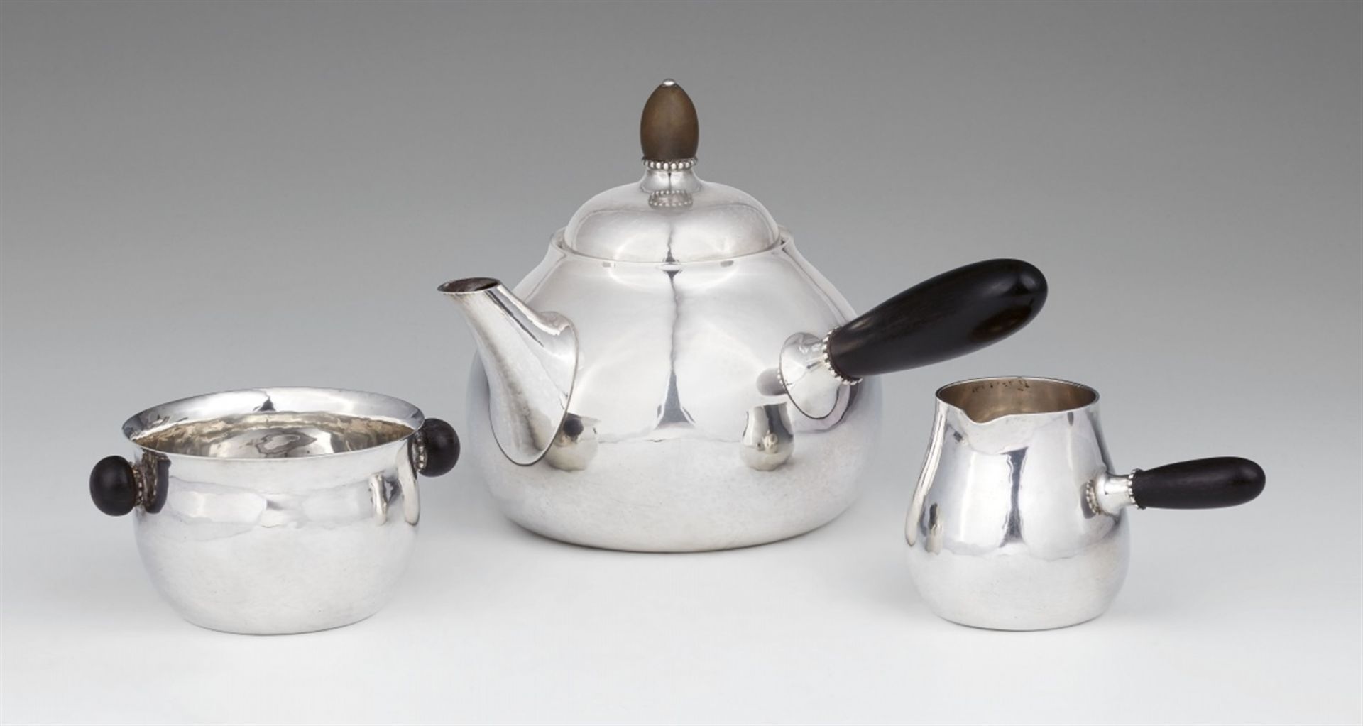 A silver tea service by Georg Jensen, model no. 80Comprising a teapot, sugar bowl, and milk jug.