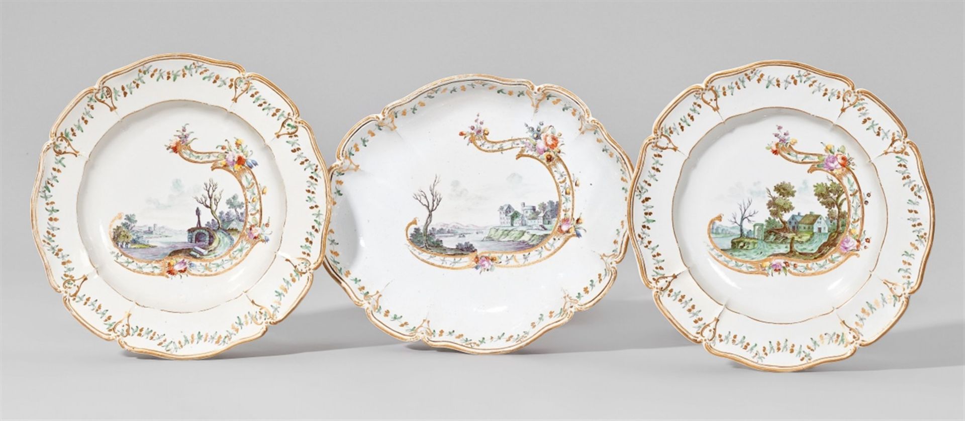 An oval Nymphenburg porcelain dish and two plates with green landscapesScalloped form with a